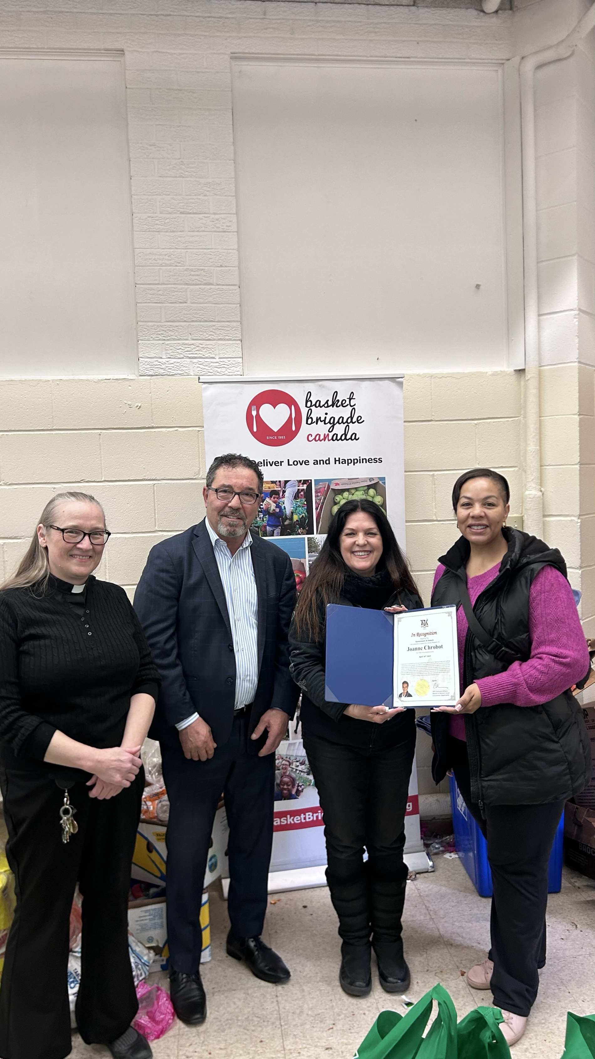 Pat Fortini presenting a recognition certificate at a Basket Brigade Canada event
