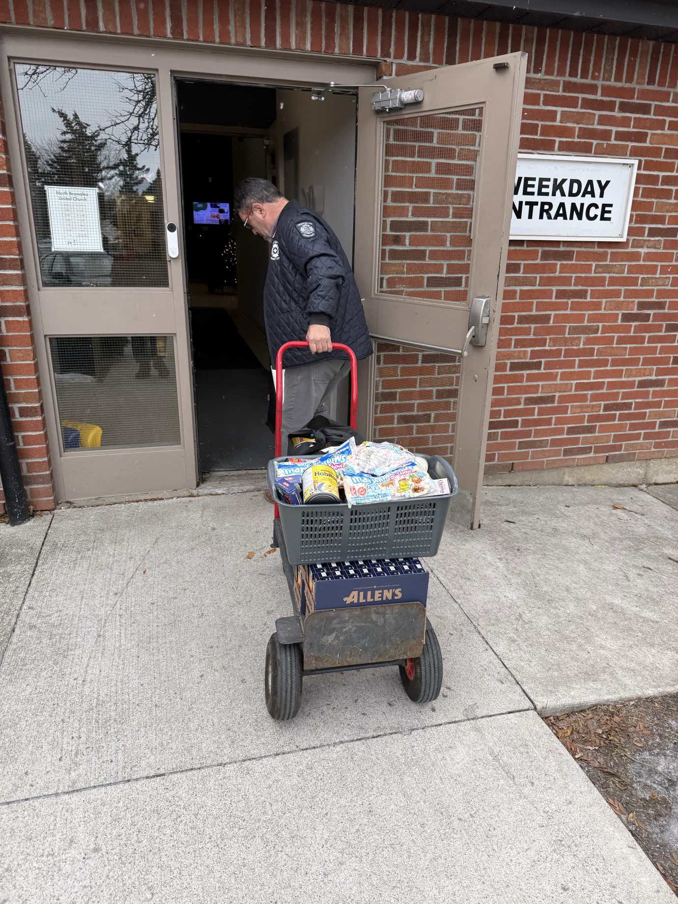 Pat Fortini delivering food donations on a cart to a church food bank
